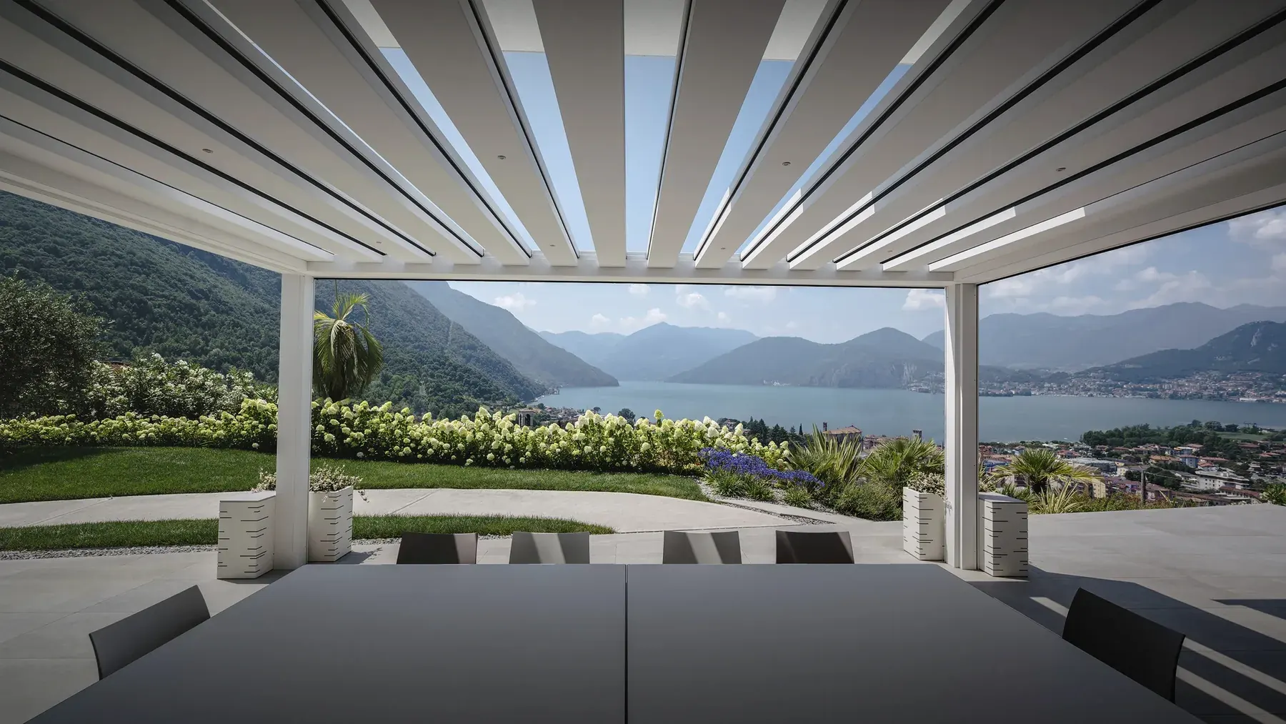 Pergola bioclimatica bianca Carrera di Pratic con vista sul lago d’Iseo.