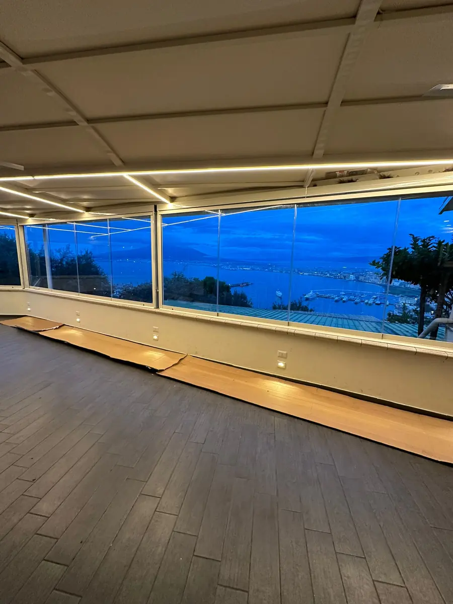 Vista serale attraverso le vetrate su muretto della stessa installazione.